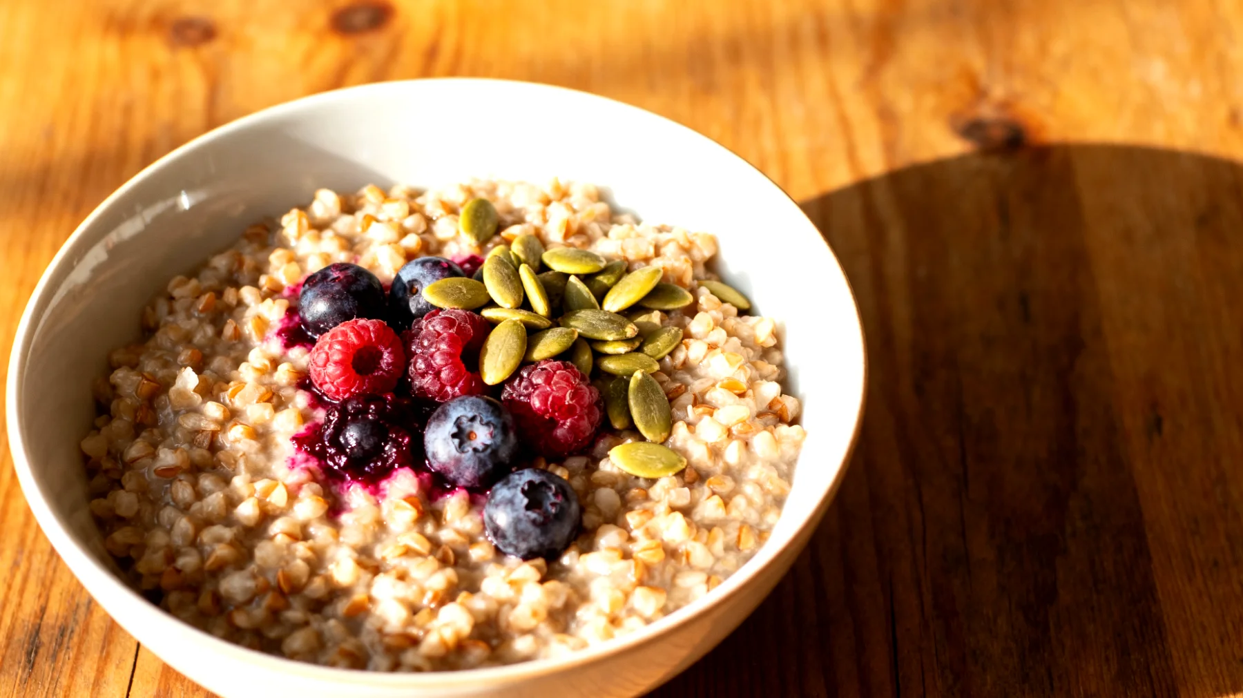 Buchweizen-Porridge mit fermentierten Beeren und Kürbiskernen"